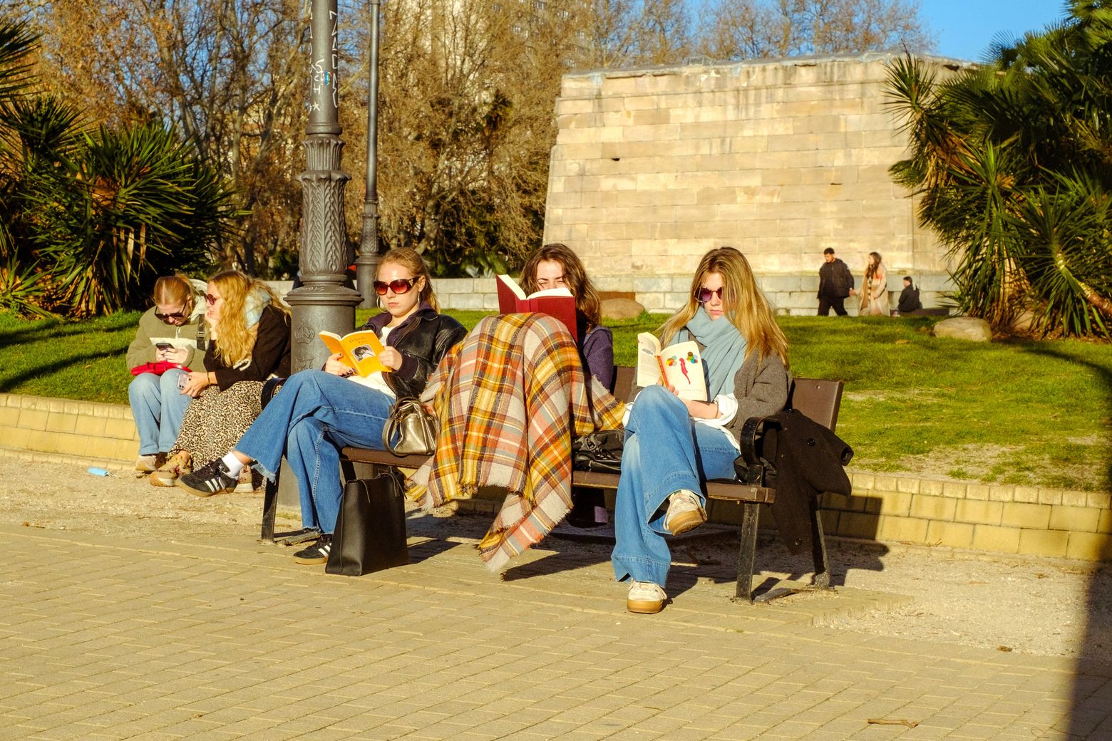 A group of friends sitting and talking together on a sunny plaza
