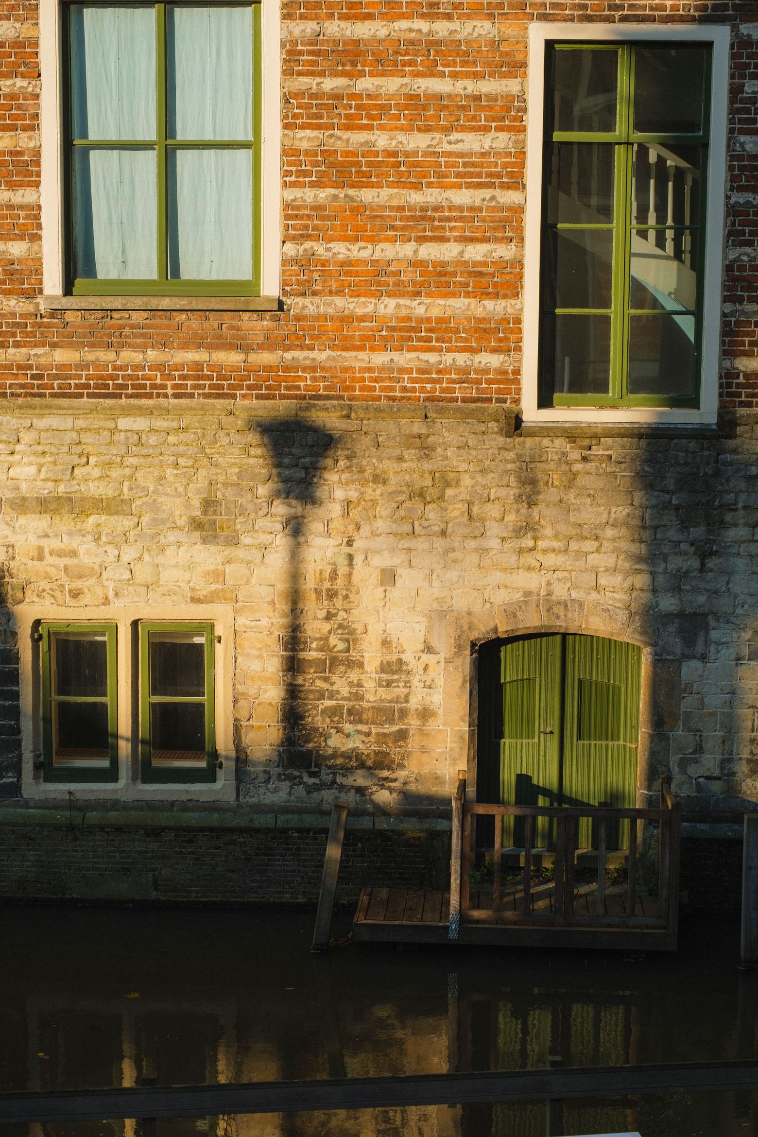 Sunlight and shadows falling across the brick facade of an old Utrecht building